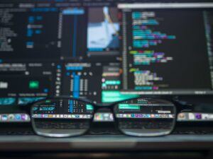 Développement WordPress sur mesure - vision développeur à travers des lunettes devant un écran de code
