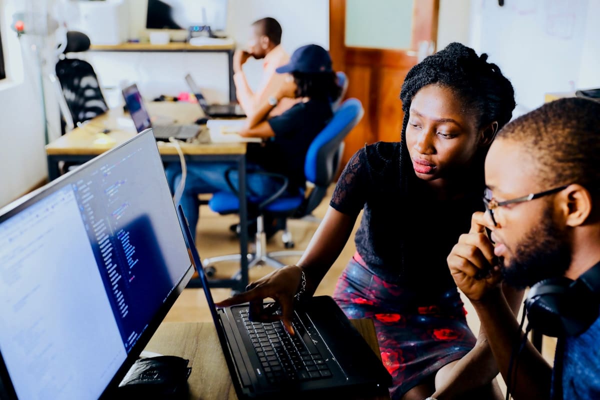 Deux développeurs web collaborant sur du code dans un espace de travail moderne à Lille